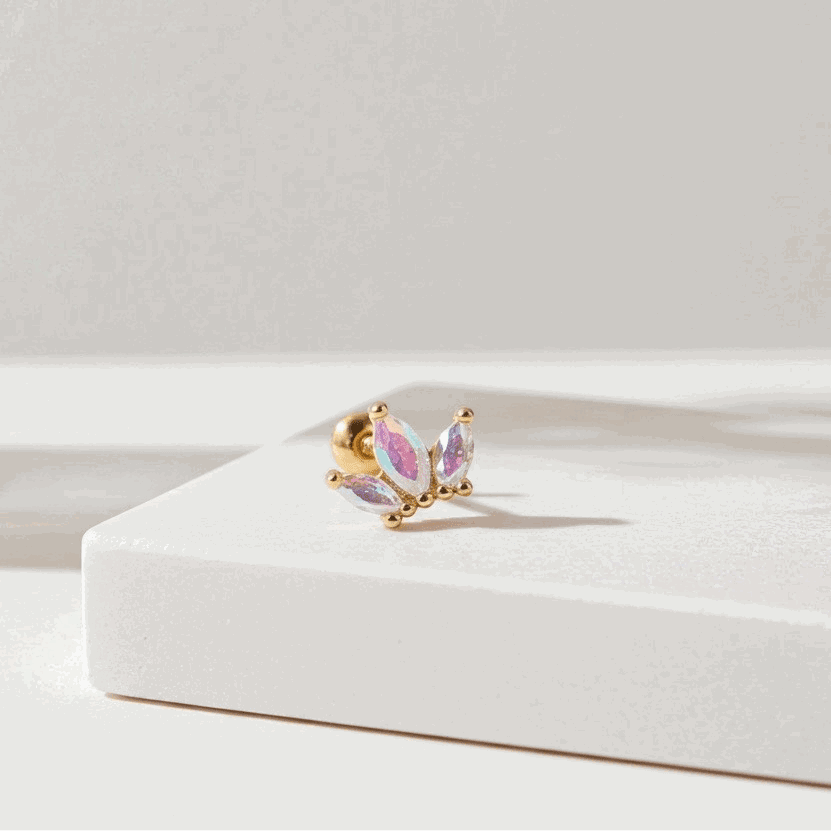 Butterfly-shaped earring on a white surface with a soft focus background
