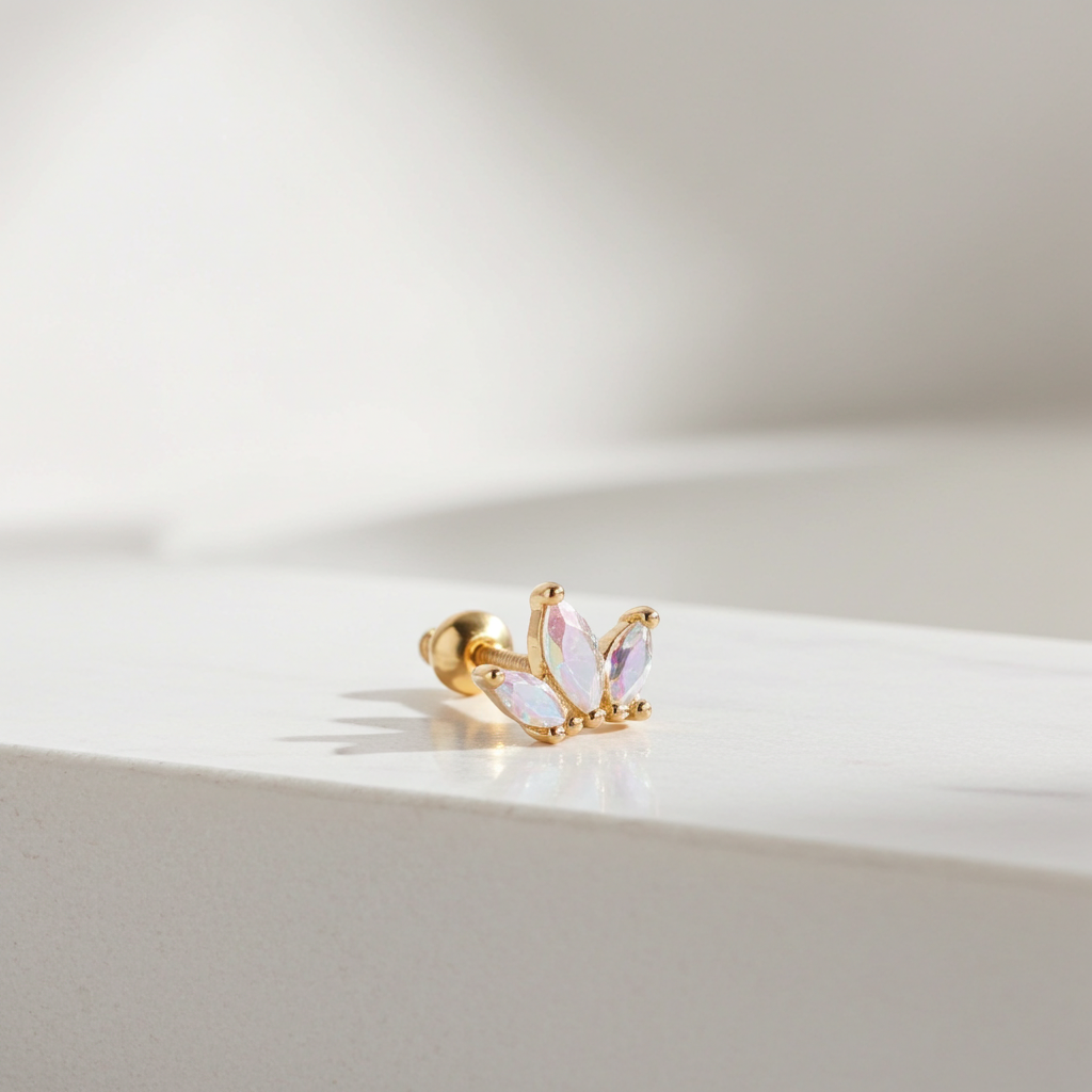 Gold earring with pink gemstones on a light background