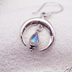 Sterling Silver earring with a teardrop-shaped Moonstone on a textured white background