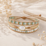Multistrand beaded bracelet with a large central moonstone on a soft beige background