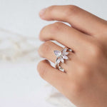 Hand wearing silver rings with moonstones gemstones on a light background