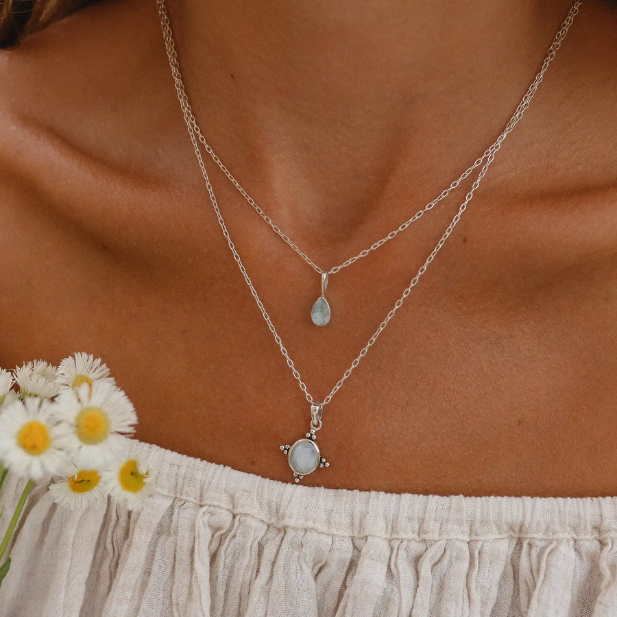 Woman wearing two rainbow moonstone necklaces stacked.