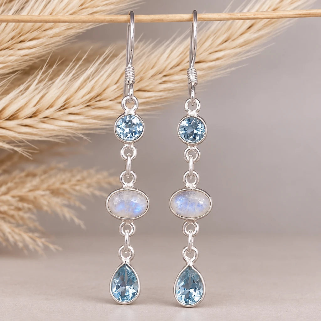 Sterling silver moonstone and blue topaz drop earrings on a natural background