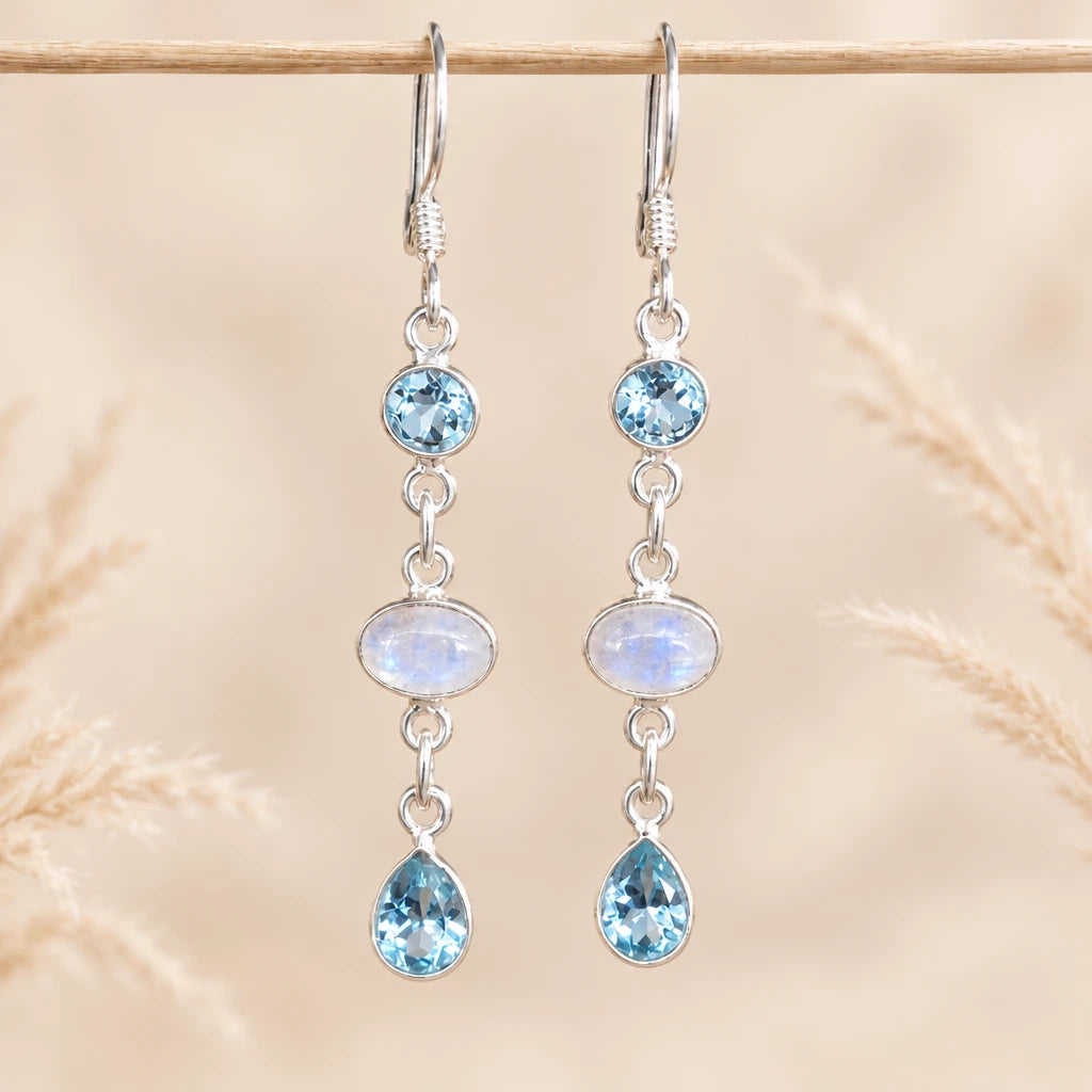 Sterling silver moonstone and blue topaz earrings on stone with dried grass