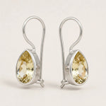 Pair of sterling silver natural citrine teardrop hook earrings on a white background