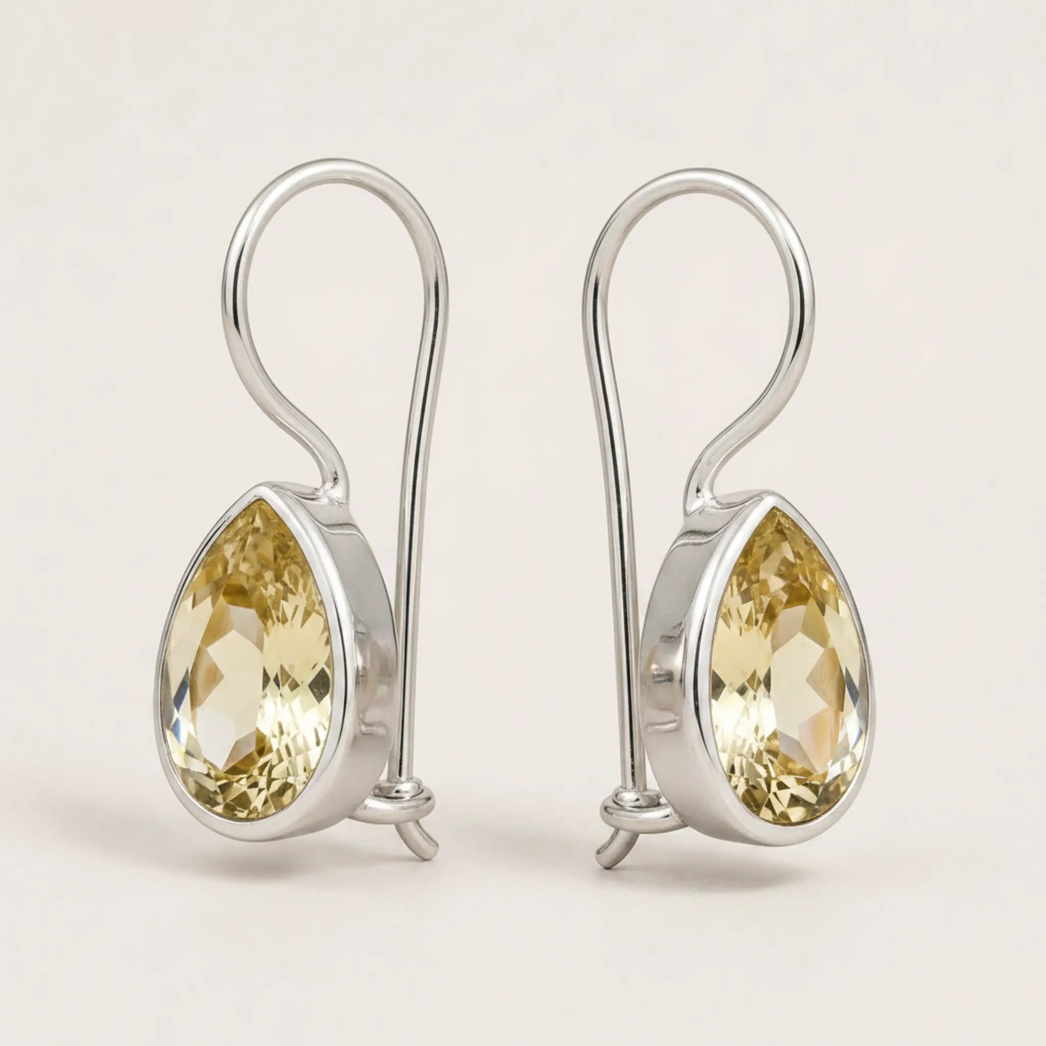 Pair of sterling silver natural citrine teardrop hook earrings on a white background