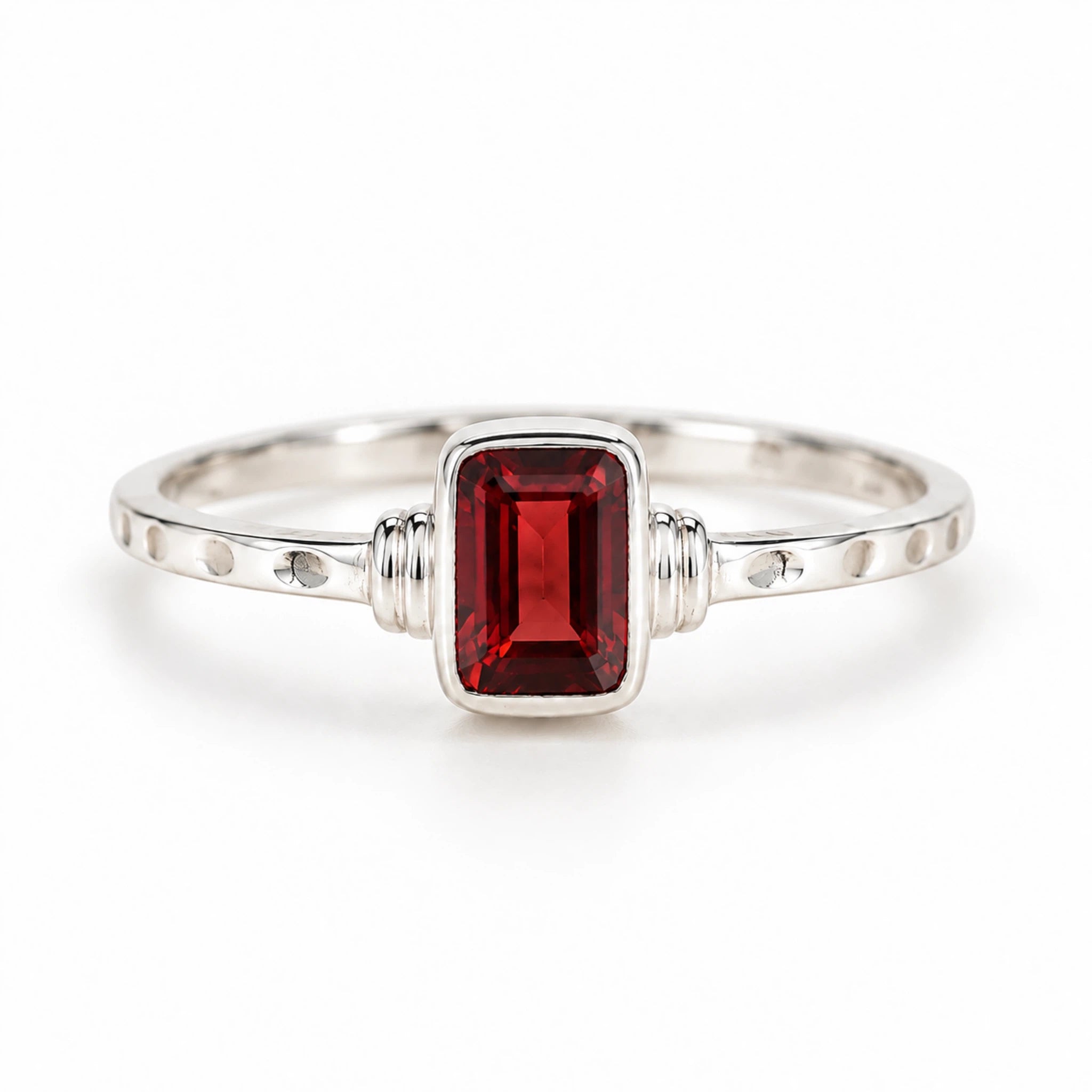 A silver garnet ring featuring a rectangular emerald-cut natural red garnet gemstone in a bezel setting, with small details on the band, shown on a clean white background.