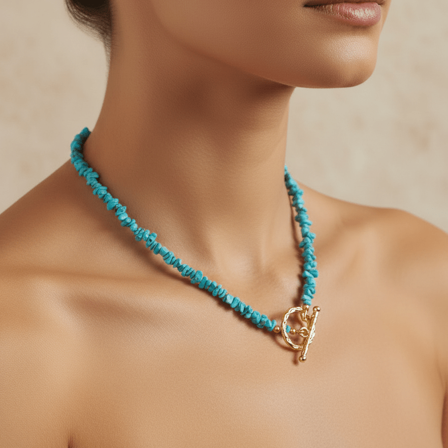 Turquoise beaded necklace with a gold clasp on a person against a neutral background