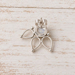 Sterling silver butterfly-shaped stud earring with a small iridescent inlay, shown on a distressed white wood background.
