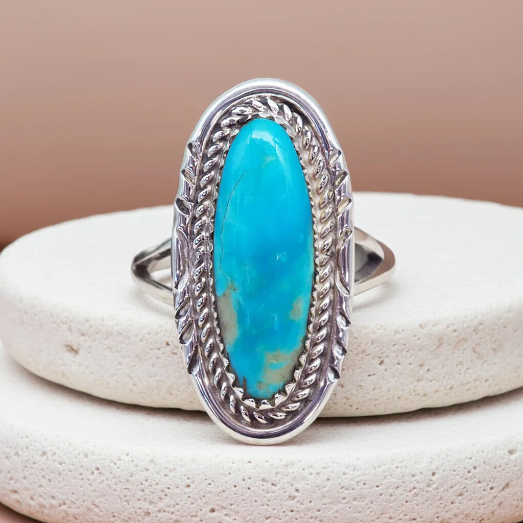 Silver ring with a turquoise stone on a beige background