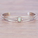 Silver bracelet with an opal stone on a wooden surface