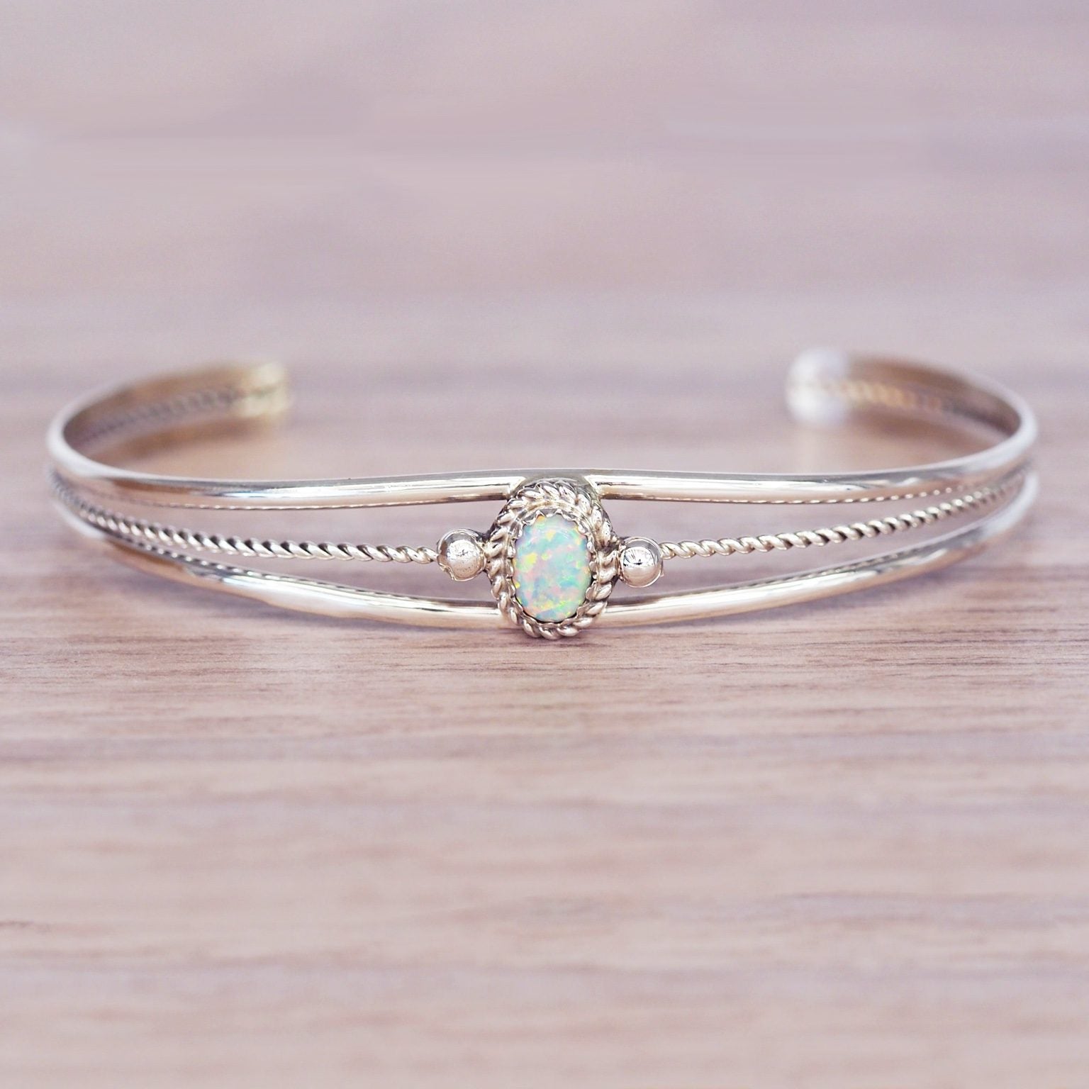 Silver bracelet with an opal stone on a wooden surface