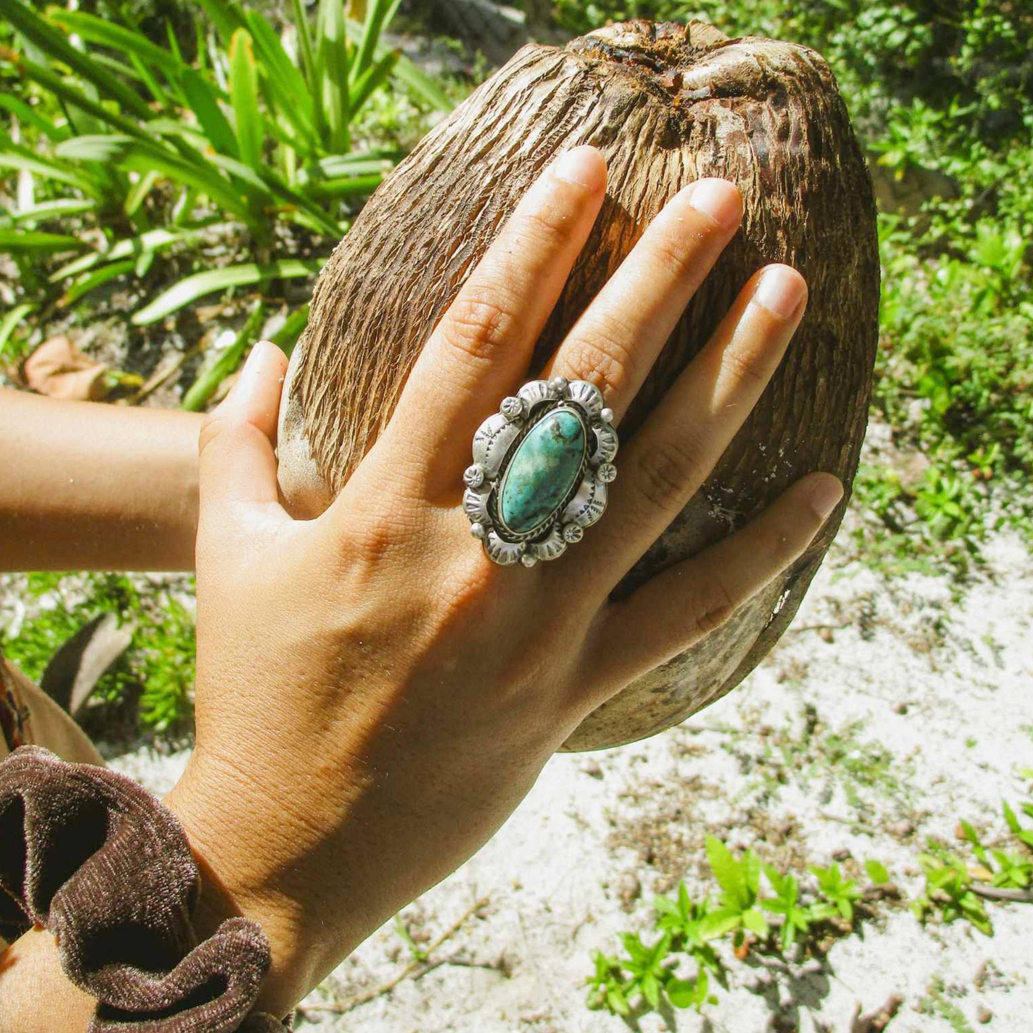 woman holding a coconut wearing silver turquoise ring by indie and harper