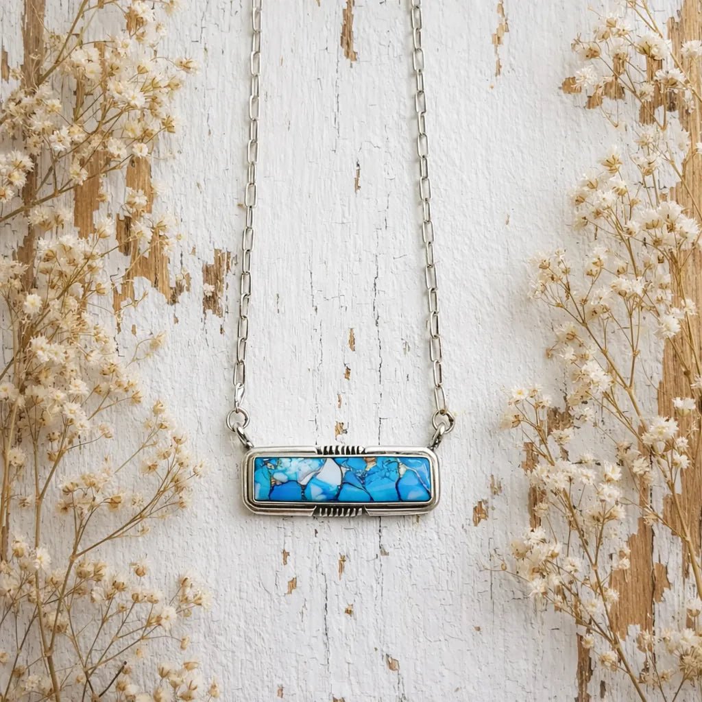 sterling silver copper turquoise necklace laying on rustic wood