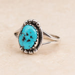 sterling Silver ring with a natural turquoise stone on a beige background which was hand crafted by navajo artisans