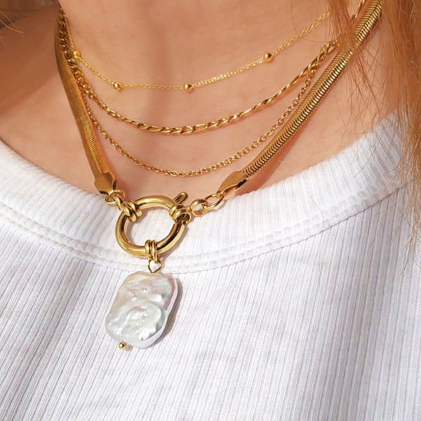 Gold necklaces with a pearl pendant on a white background