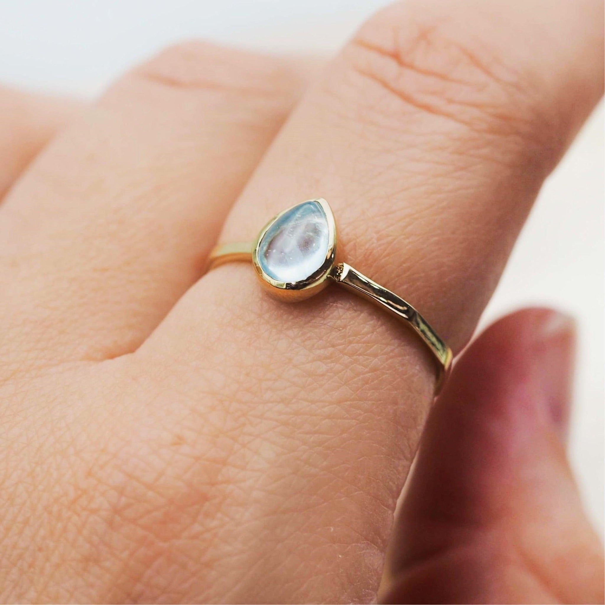 finger wearing gold november birthstone blue topaz ring - womens jewellery by australian jewellery brand indie and harper