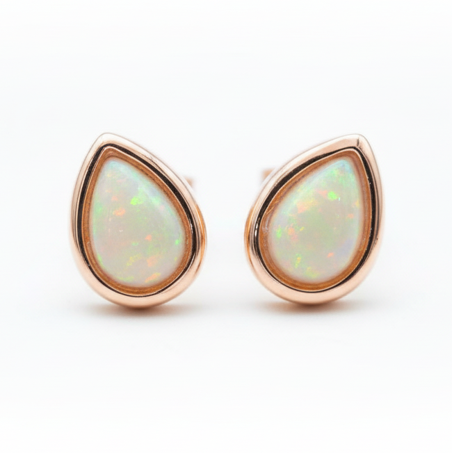 Teardrop-shaped opal earrings with rose gold setting on a white background