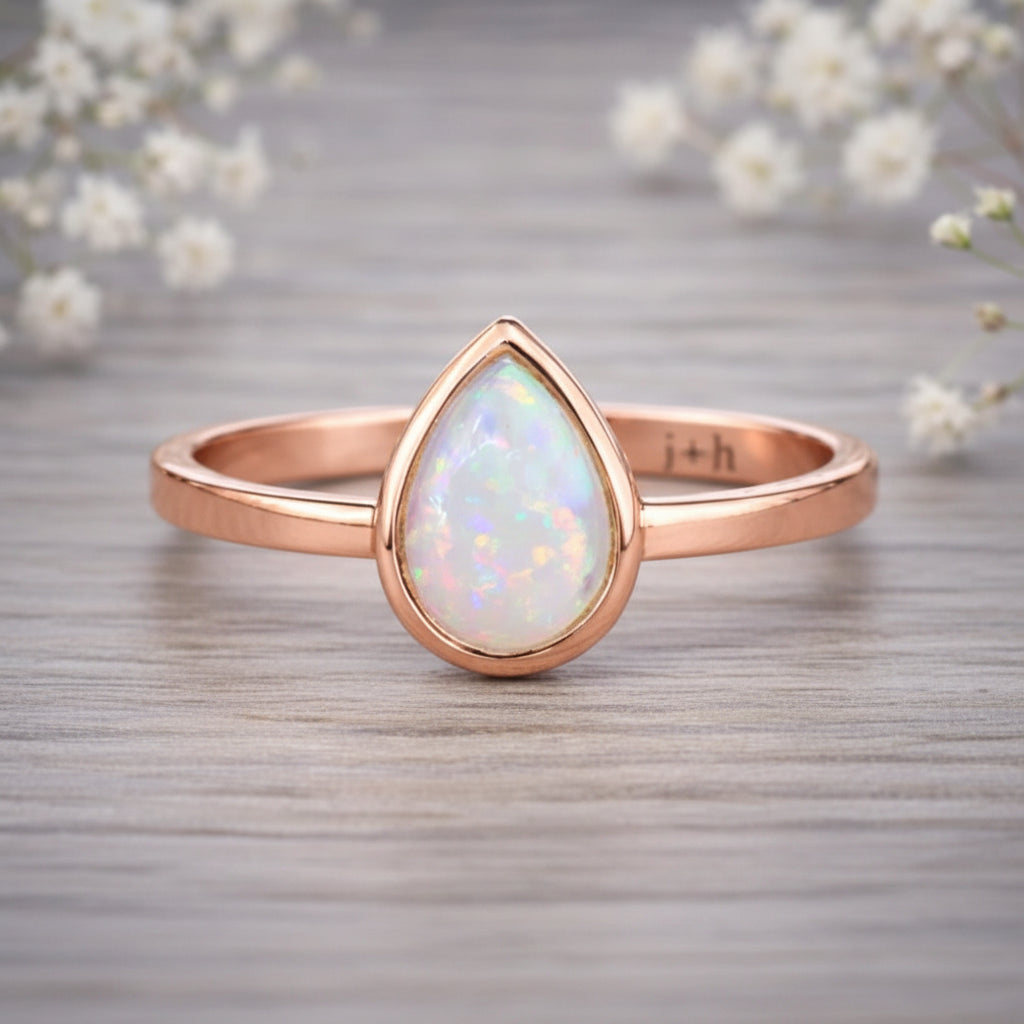 Rose gold October birthstone ring with a pear-shaped opal stone as a meaningful birthstone jewellery gift for her.