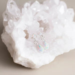 Opal teardrop earrings on a white crystal background