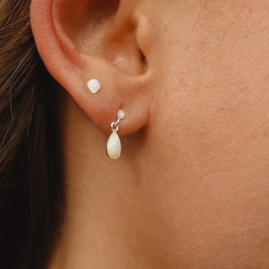 woman wearing teardrop shaped opal stud and small drop opal earring