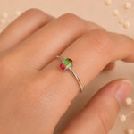 sterling silver oval watermelon tourmaline ring with green and pink colours worn on a finger against a light background