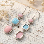 sterling silver french hook earrings with natural pink opal and larimar gemstones on rustic wooden background