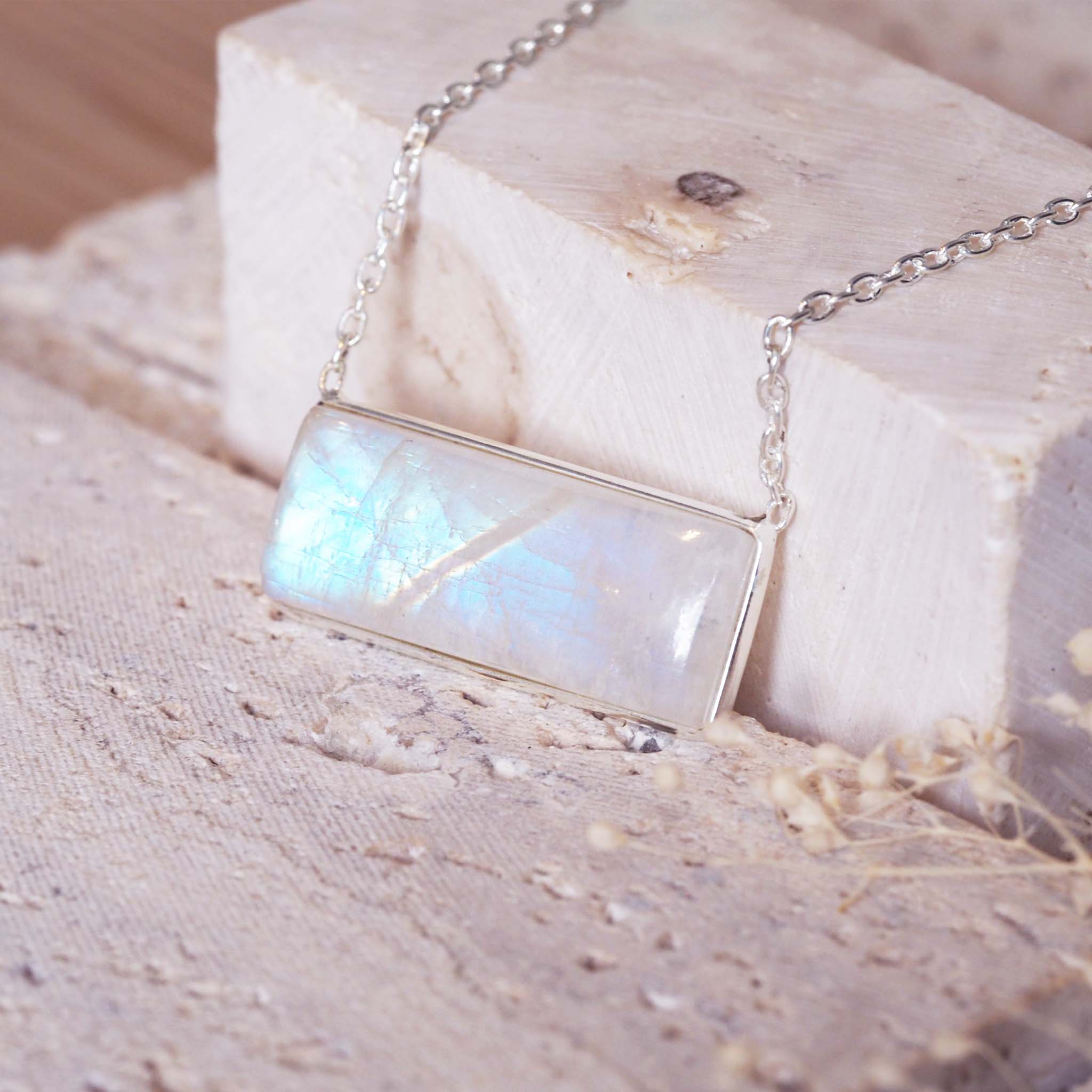 sterling silver moonstone Necklace with a rectangular natural rainbow moonstone pendant on a textured surface