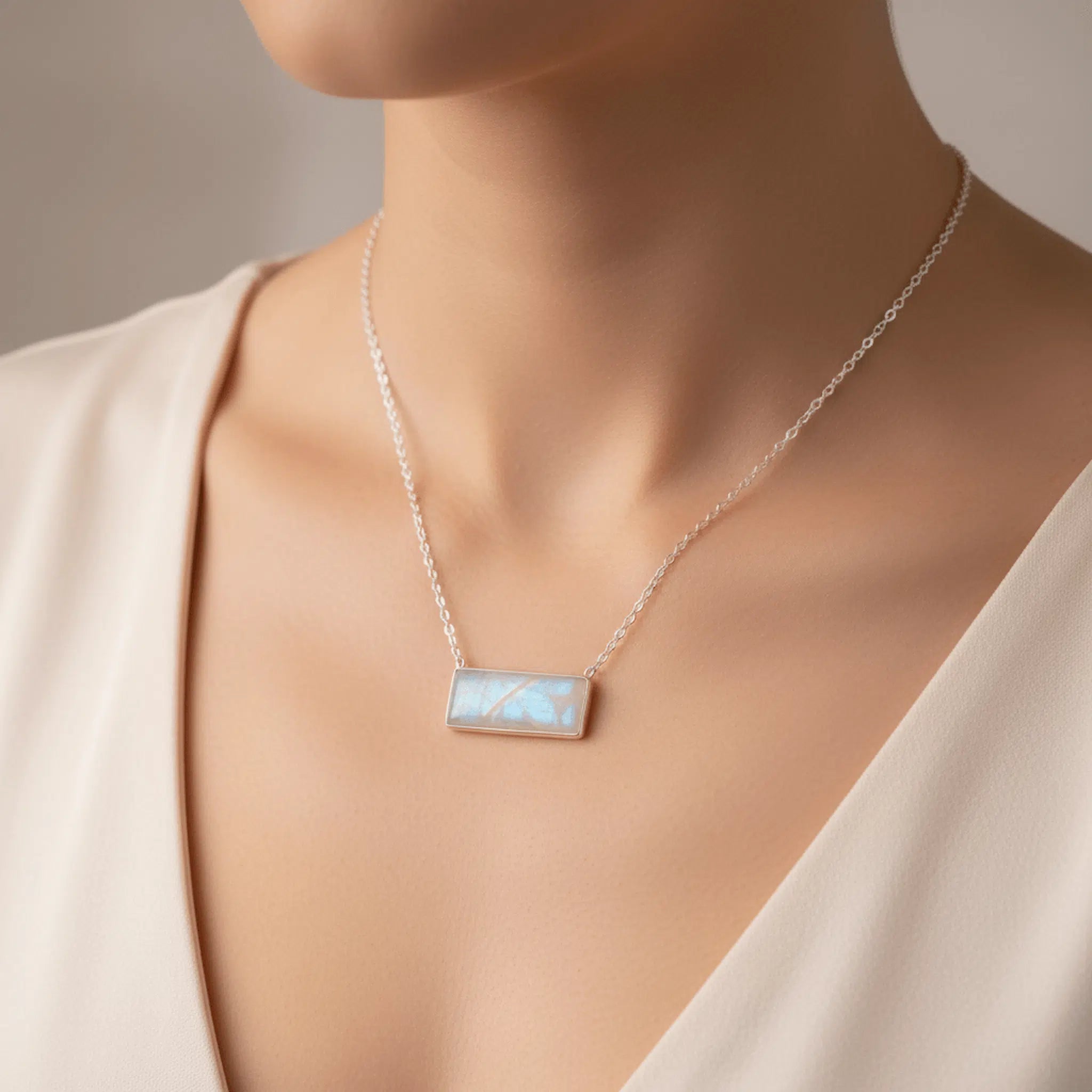 sterling silver chain necklace with a large rectangle natural moonstone gemstone pendant being worn