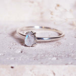 Silver ring with a moonstone on a textured surface