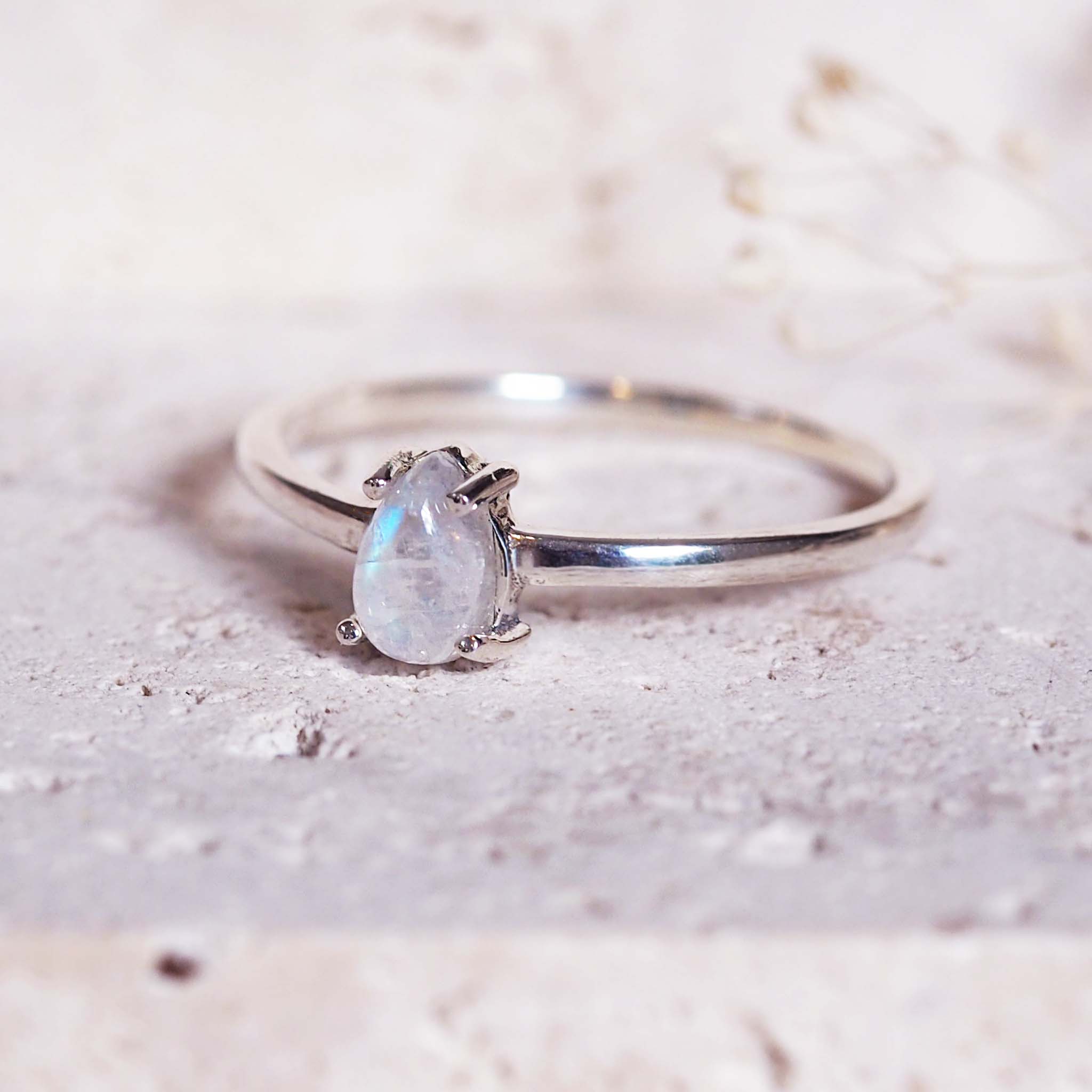 Silver ring with a moonstone on a textured surface
