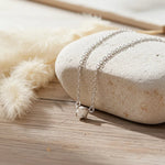 sterling Silver raw white diamond on a stone surface