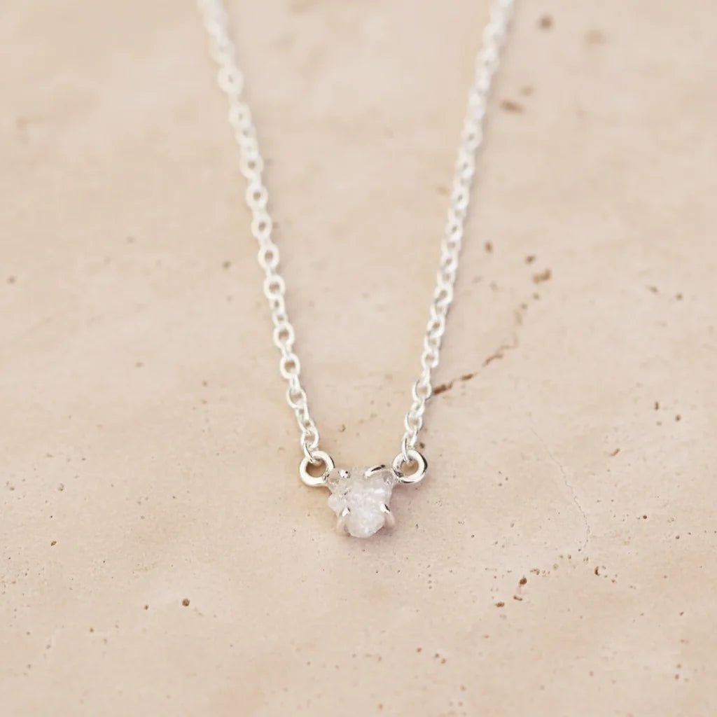 Sterling Silver Necklace with a Raw White Diamond on a beige background