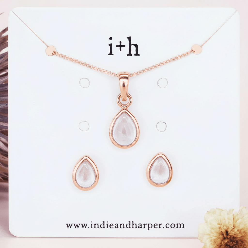 Rose gold teardrop necklace and earrings set on a branded card with 'i+h' and website URL.