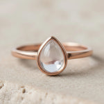 Rose gold April Birthstone ring with a teardrop-shaped natural Clear Quartz gemstone on a neutral background