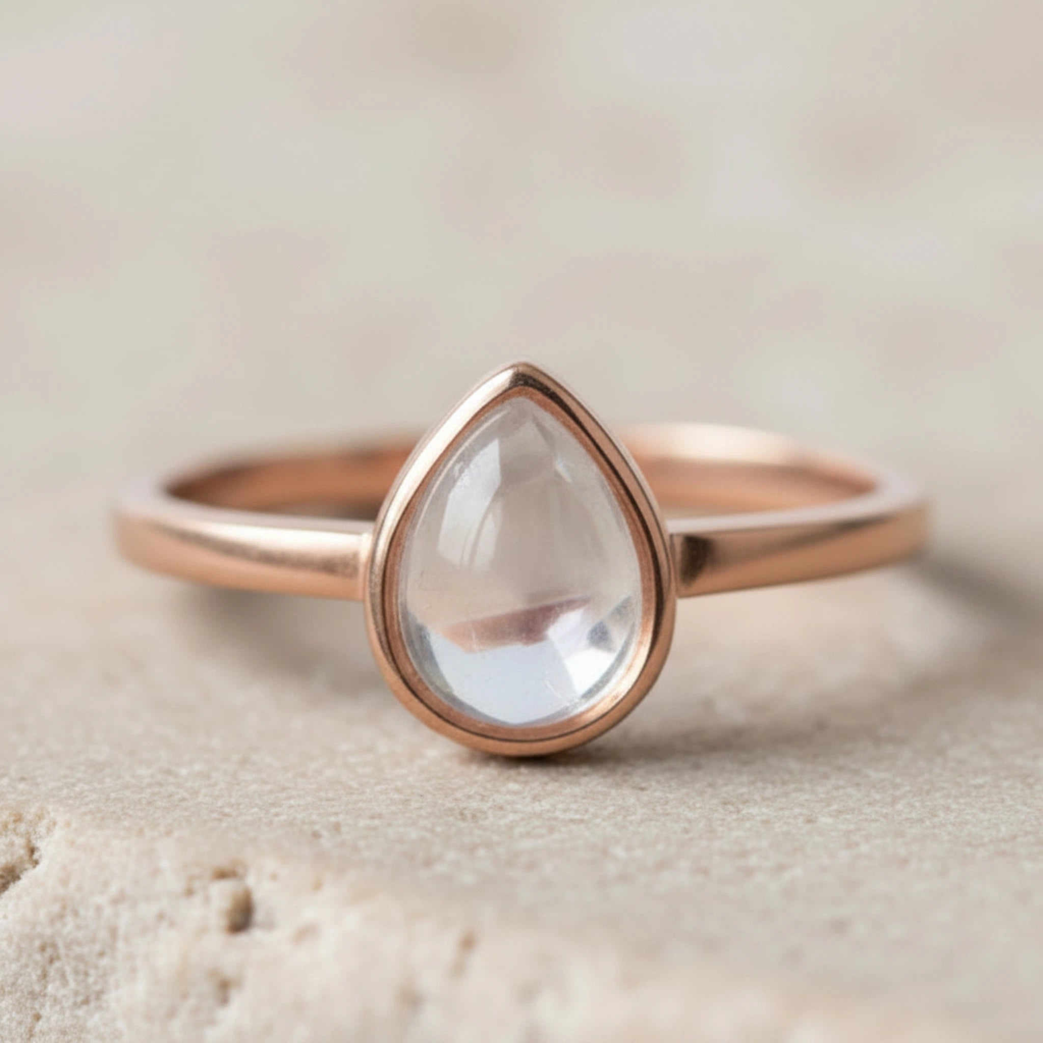 Rose gold April Birthstone ring with a teardrop-shaped natural Clear Quartz gemstone on a neutral background