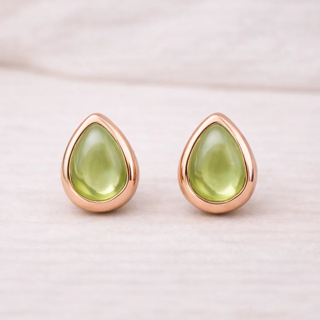 Teardrop-shaped green natural peridot gemstone stud earrings with rose gold frames on a light background