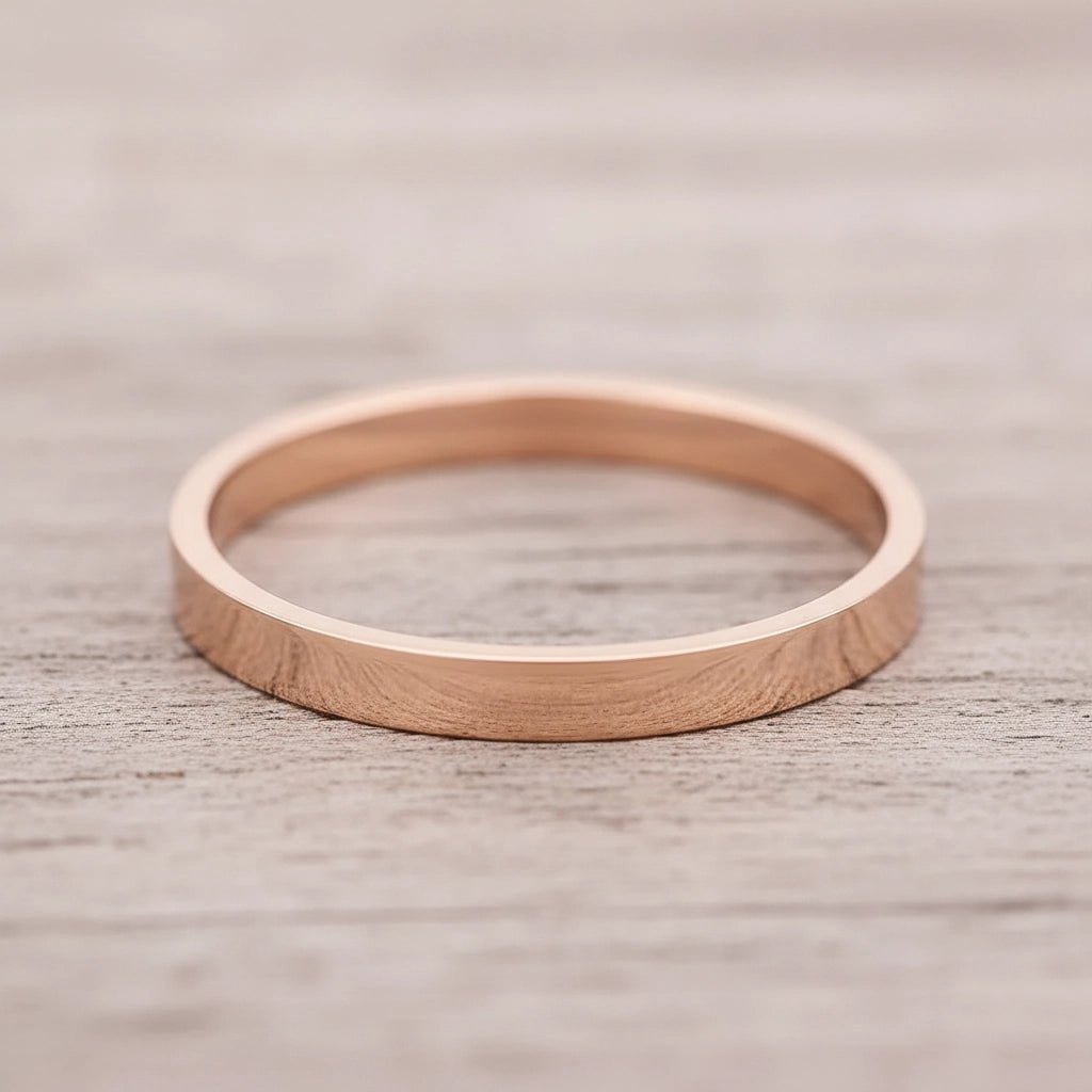 Rose gold band ring on a wooden surface
