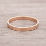 Rose gold band ring on a wooden surface