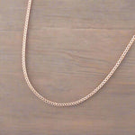 Minimalist Rose Gold chain necklace on a wooden surface