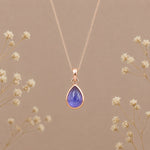 Indie and Harper December birthstone necklace with teardrop tanzanite pendant in rose-gold setting