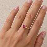 rose gold july birthstone ring being worn featuring a pear-shaped cabachon bezel-set natural ruby being worn