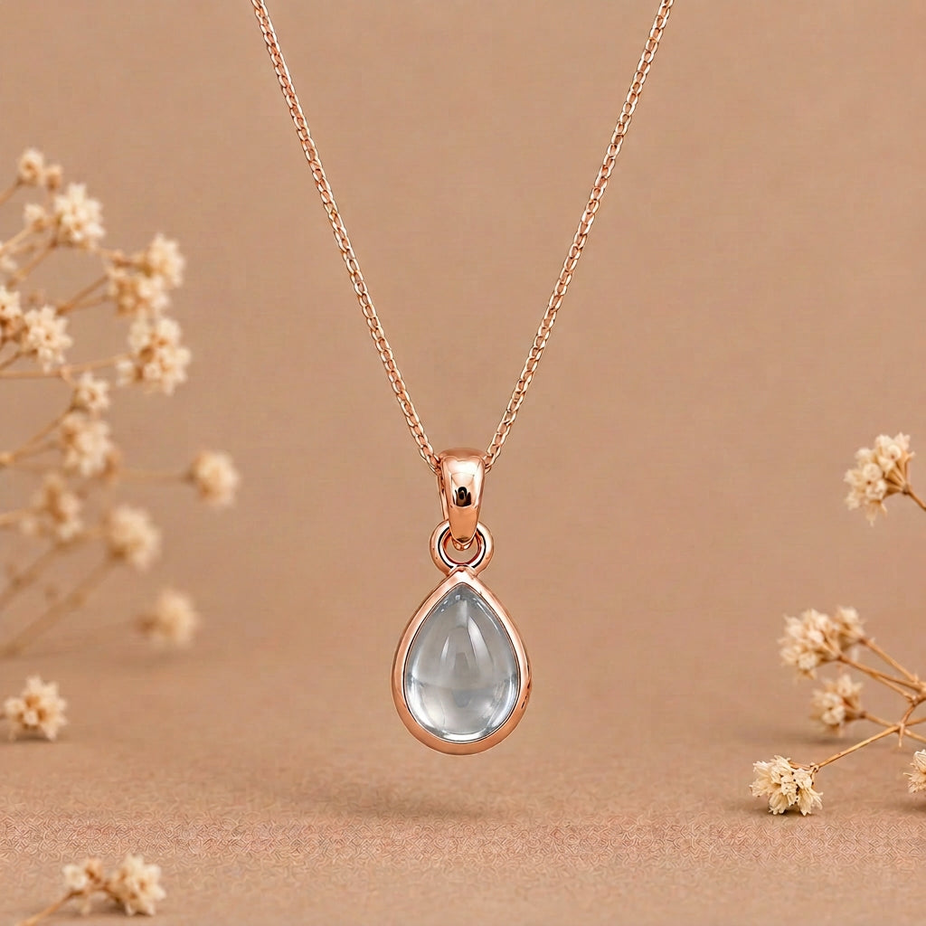 Rose gold March birthstone necklace with a pear-shaped aquamarine pendant on a fine curb chain