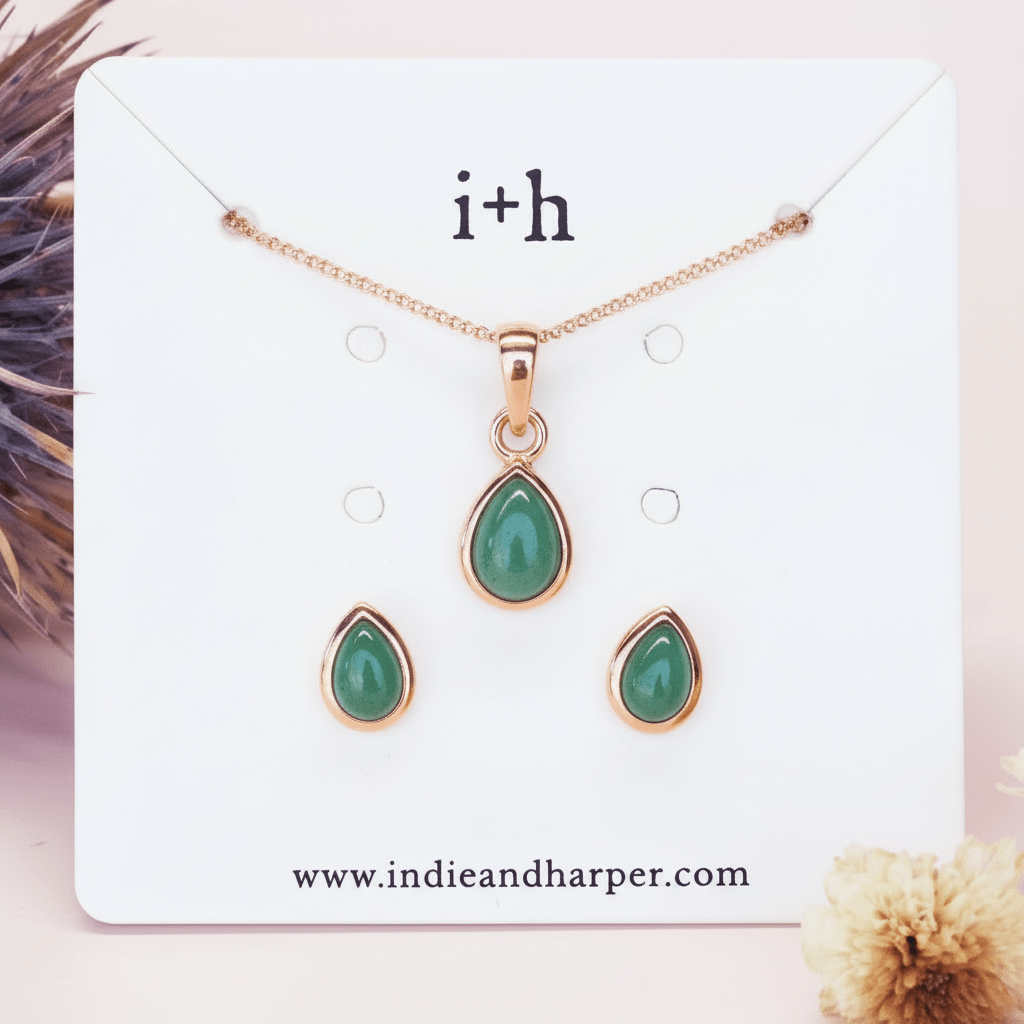 Jewelry set with green teardrop pendants on a display card with 'i+h' branding.