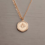 Rose gold necklace with a star pendant on a gray background