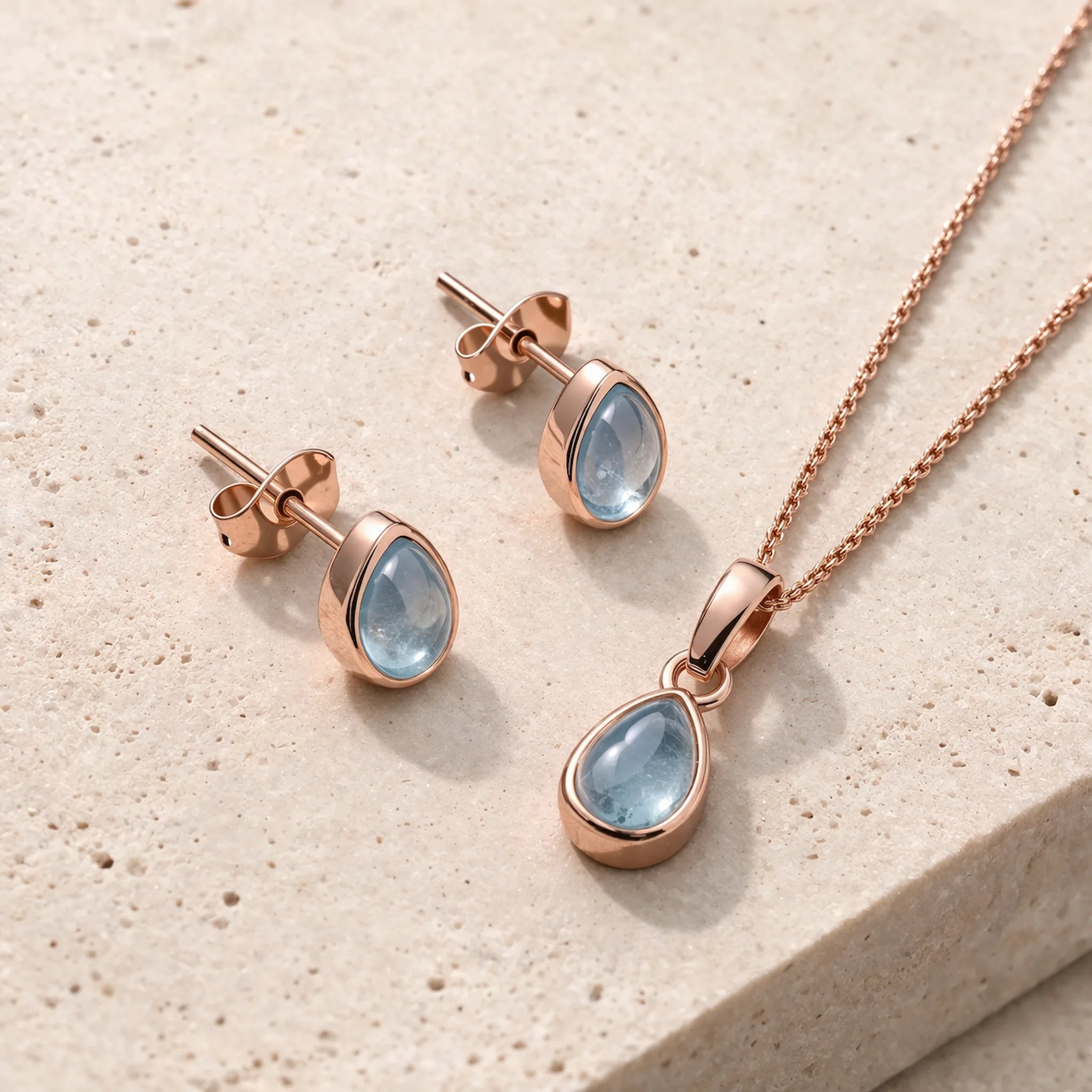 Rose Gold November Birthstone Jewellery Set including pear-shaped natural blue topaz stud earrings and pendant necklace