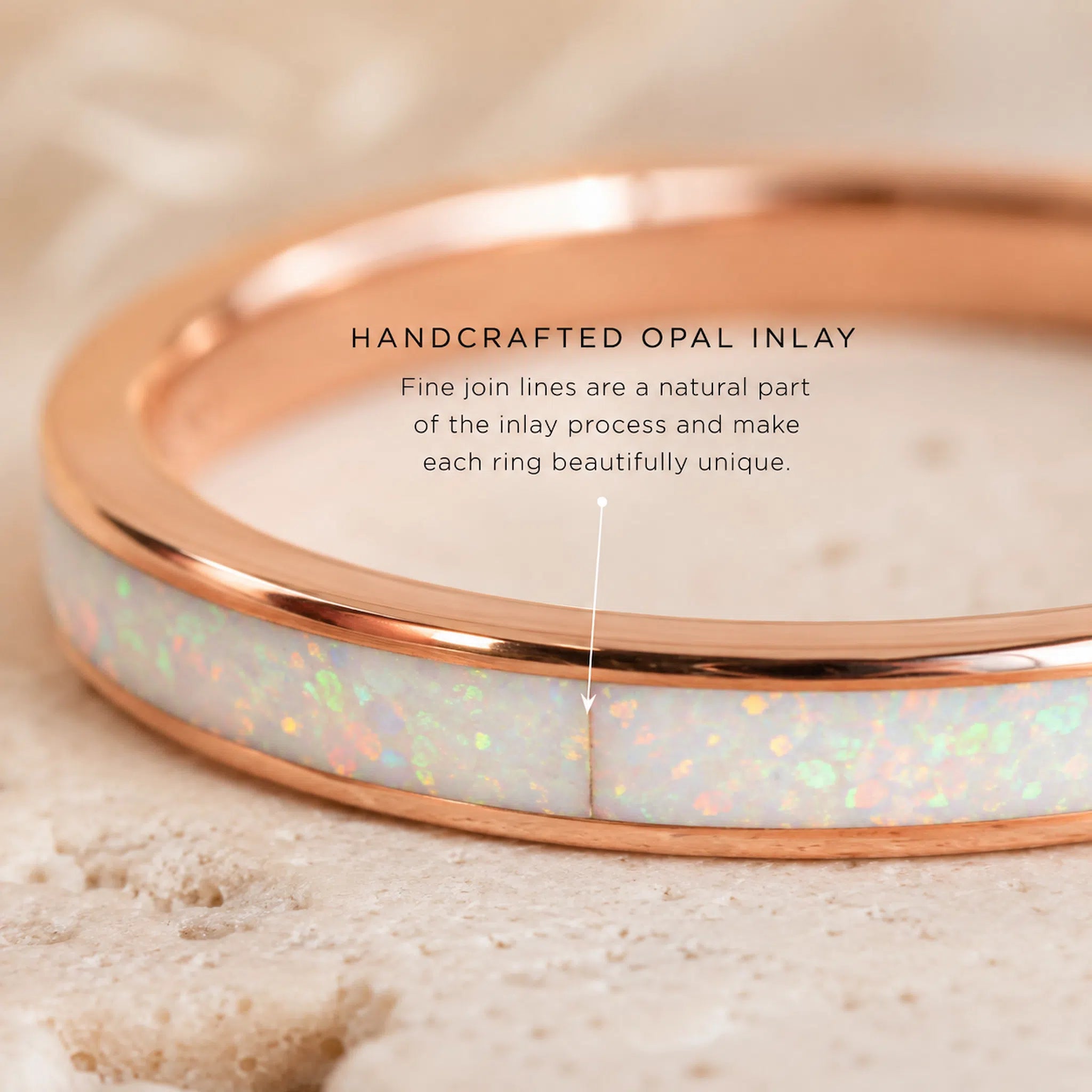 Rose gold ring with opal inlay on a beige background