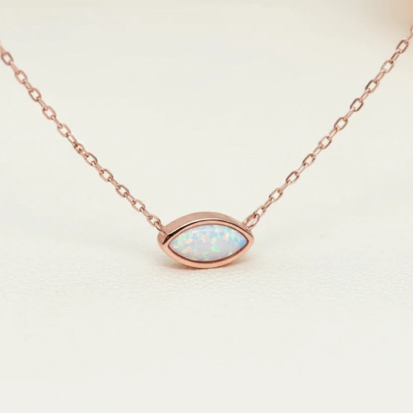 Necklace with an opal pendant on a white stone with a blurred natural background