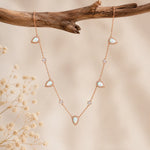 rose gold necklace with teardrop white opals and czs hanging