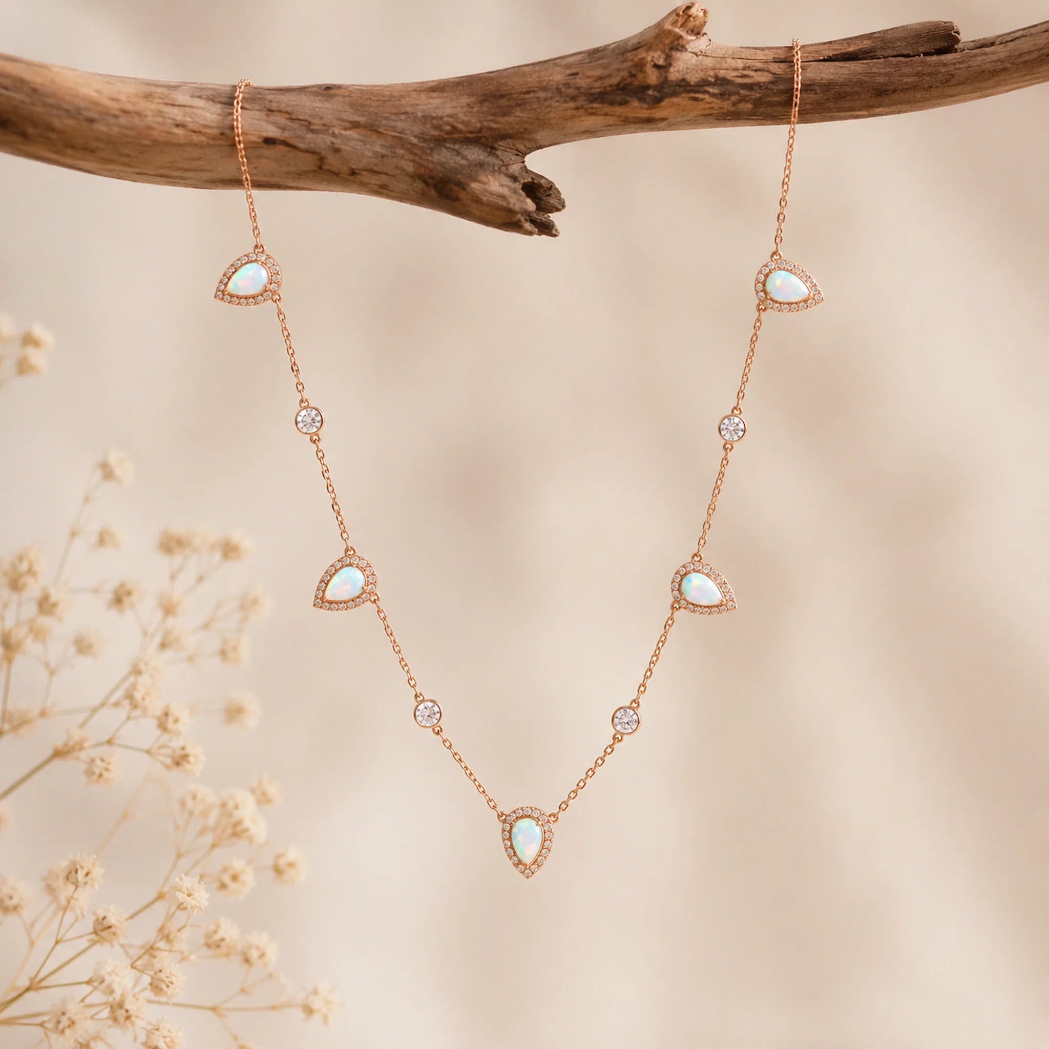 rose gold necklace with teardrop white opals and czs hanging